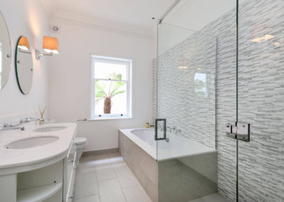 Penman Interiors Chelsea Bathrooms Neutral Stone Feature Wall Glass Shower Cubicle Double Sink Curved Bespoke