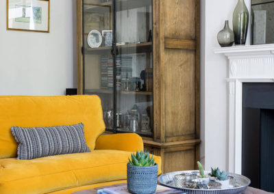 Penman Interiors Dulwich Living Room Ochre Yellow Sofas Buttoned Ottoman Vintage French Glass Cabinet